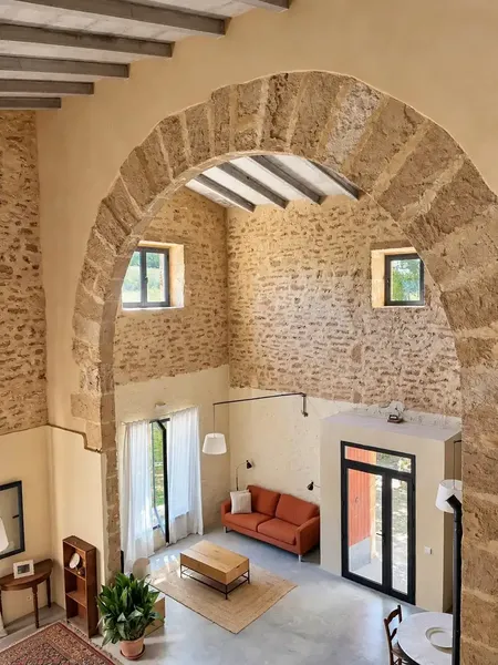 Piedra natural, un gran arco y techos de gran altura con vigas vistas definen el carácter de esta casa de campo tradicional mallorquina ubic — photo 4