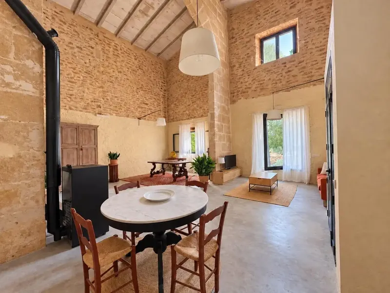 Piedra natural, un gran arco y techos de gran altura con vigas vistas definen el carácter de esta casa de campo tradicional mallorquina ubic — photo 2